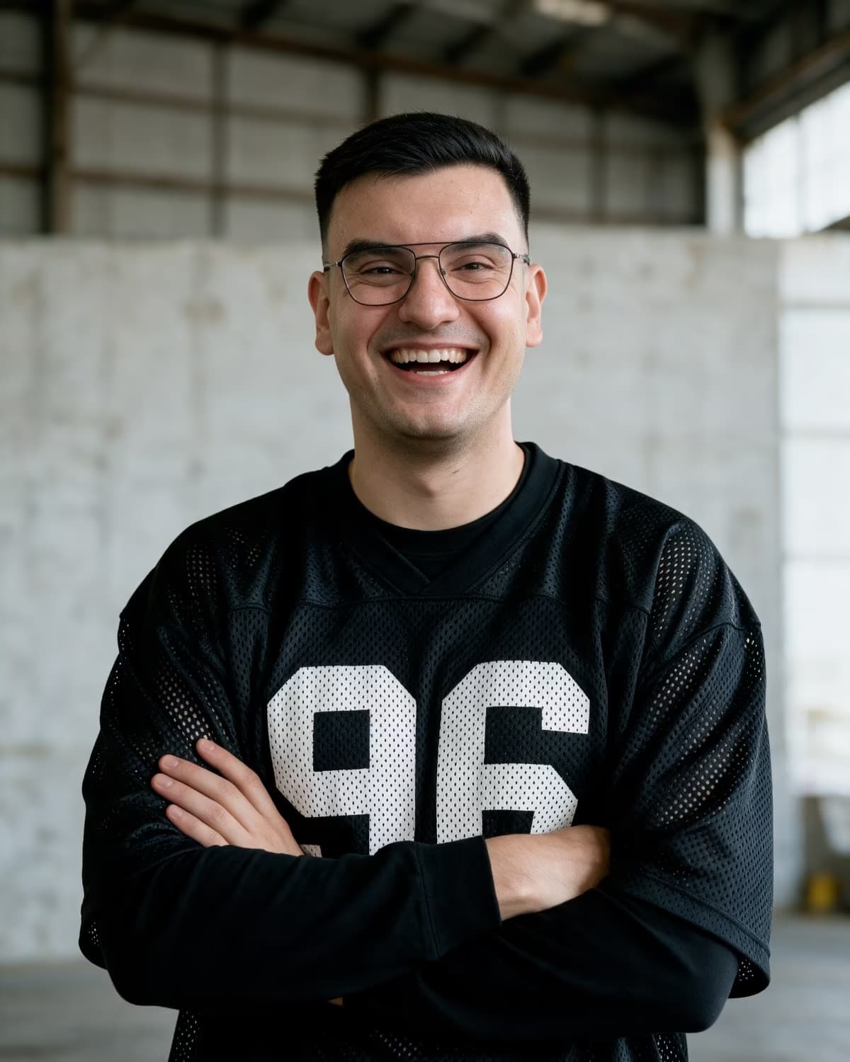 Damjan Savić im Hangar, Arme verschränkt, lachend in die Kamera