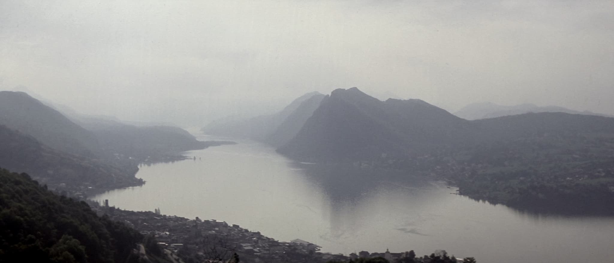 Der See im Dunst, die Stadt am Ufer, ein Grat darüber